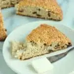 a wedge shaped spice and fruit scone on a white plate