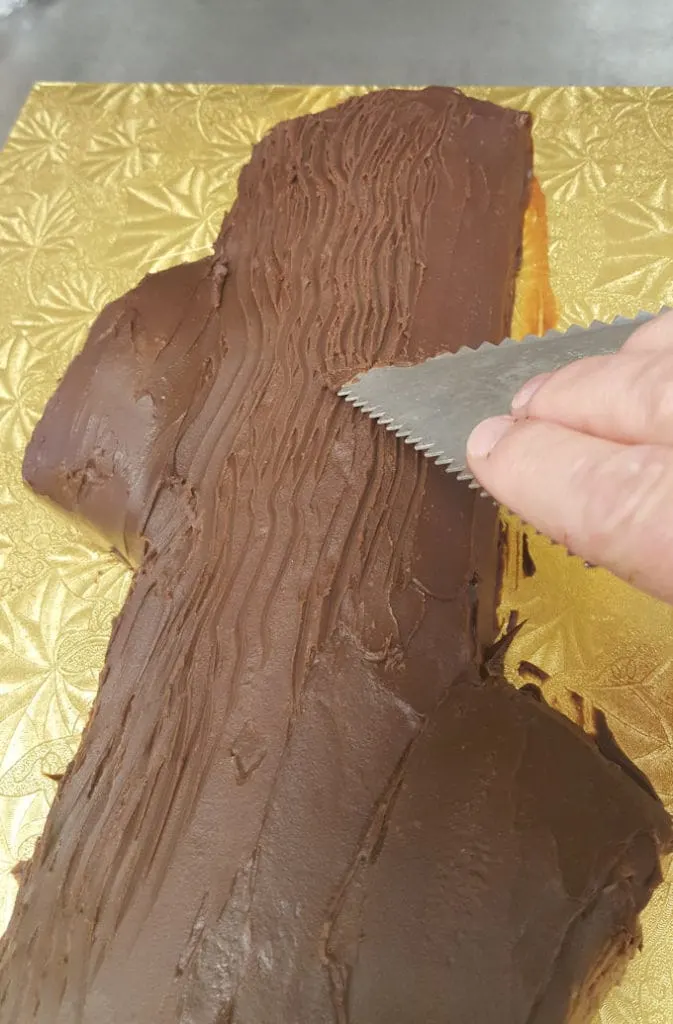 a icing comb creating lines in a chocolate cake
