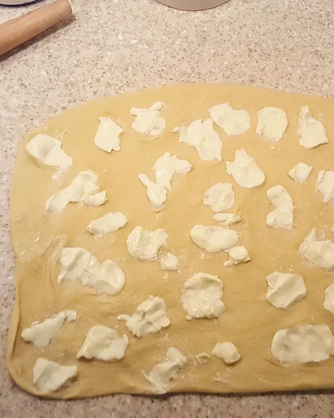 dotting butter over dough to create flaky layers