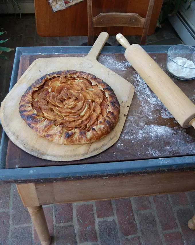 a freshly baked apple cinnamon galette on a wooden peel 