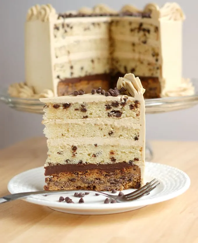 A slice of chocolate chip cookie cake on a white plate with a fork