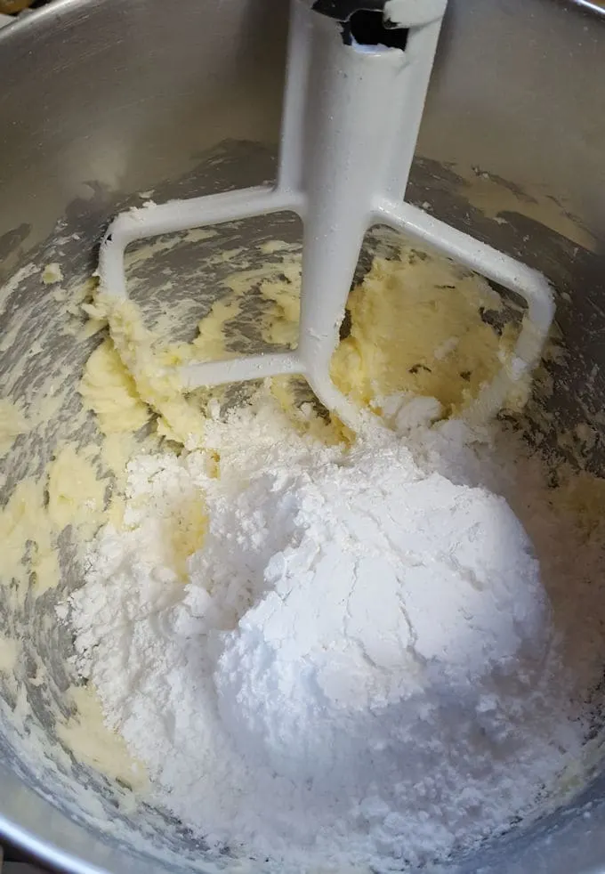 a mixing bowl with butter and powdered sugar