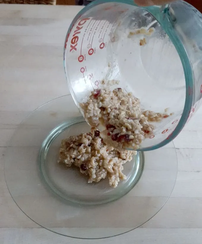 pouring leftover oatmeal onto a plate to make a crispy oatmeal pancake