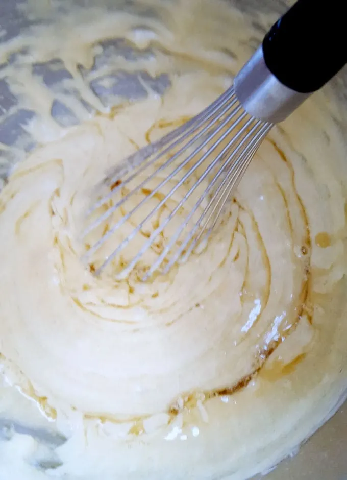 a whisk mixing browned butter into batter
