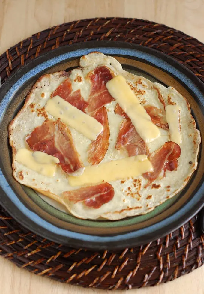 a savory Dutch Pancake with Speck and Gouda on a plate