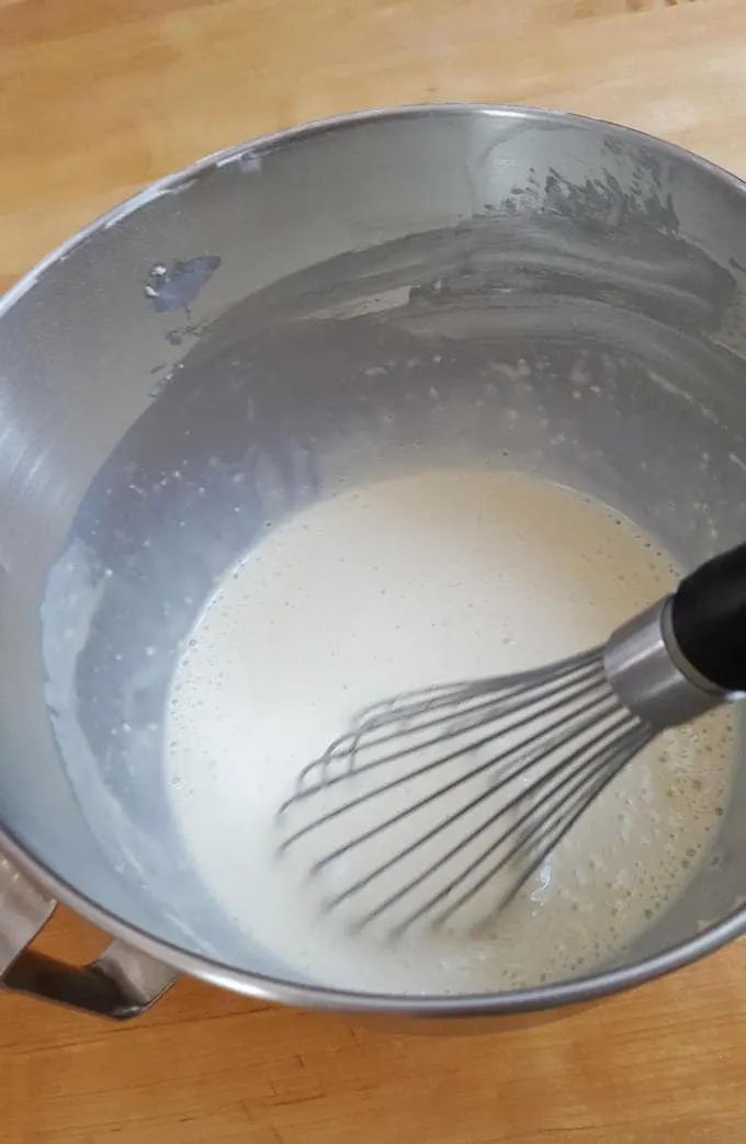 whisking dutch pancake batter in a bowl