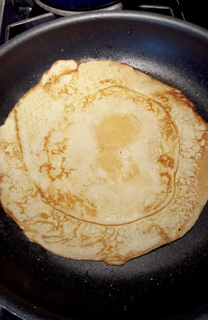 a large dutch pancake in a pan, browned side up