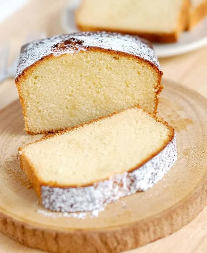 a sliced honey pound cake on a wooden cake plate