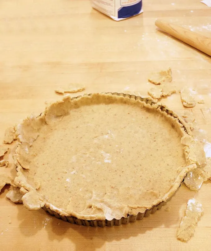 showing how to line a tart pan with nut dough