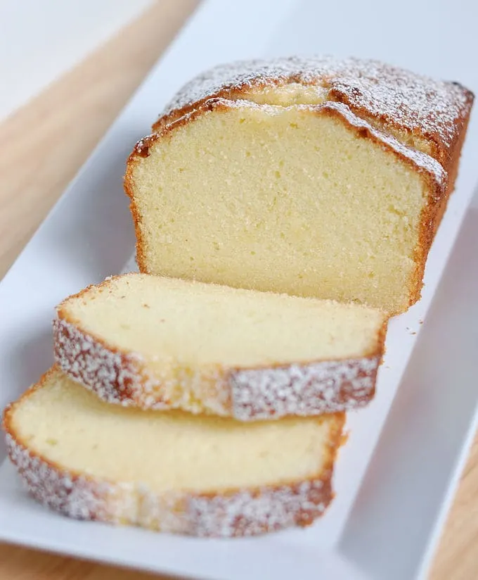 A sliced pound cake on a white tray