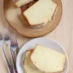 An overhead view of two slices of pound cake on a white plate and a slice cake on a wooden cake stand.