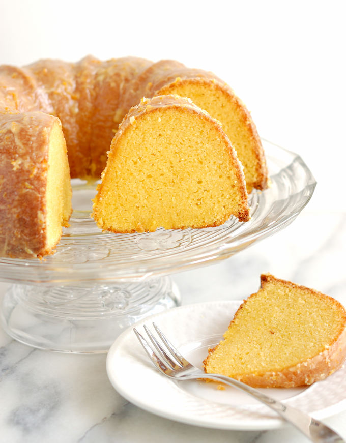a golden beet orange cake on a glass cake stand.,