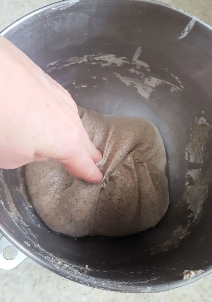 folding sourdough bread in a bowl