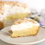 a slice of pina colada pie with rum whipped cream on a white plate