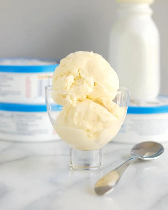 a glass bowl with two scoops of creme fraiche ice cream and a spoon