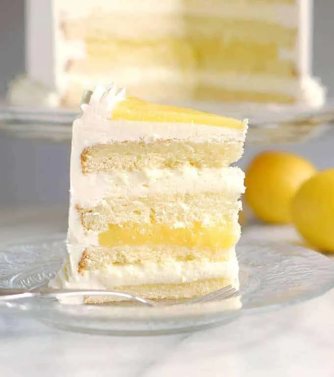 a slice of lemon mousse cake on a glass plate with a fork