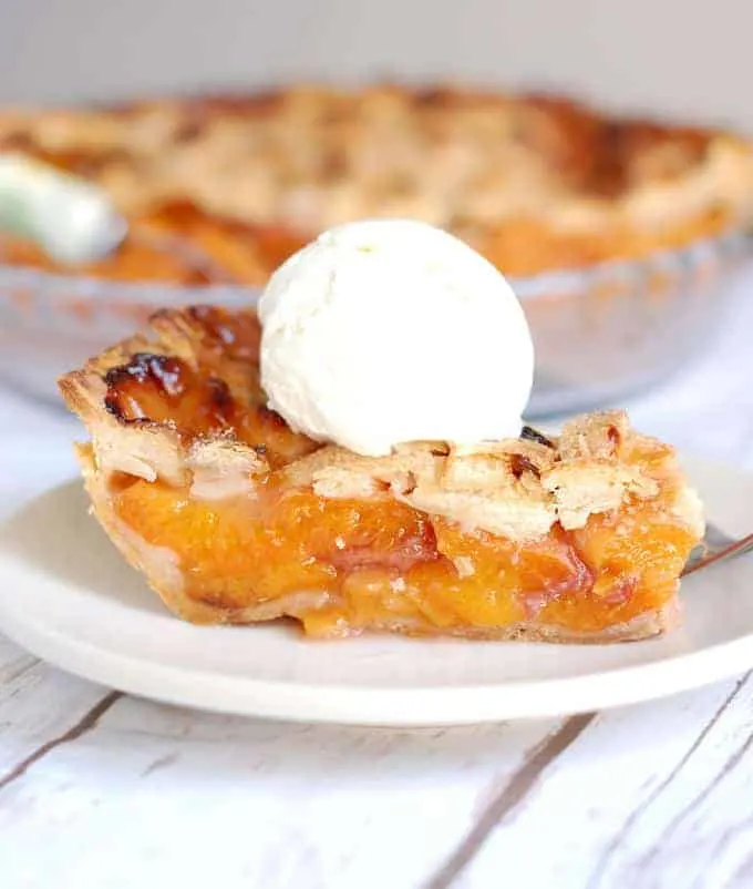 a slice of apricot raspberry pie on a plate