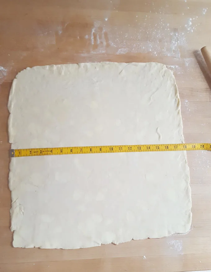 a pie of roll dough with a measuring tape.