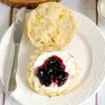 a Fresh Corn Scone on a white plate with cream and jam on top