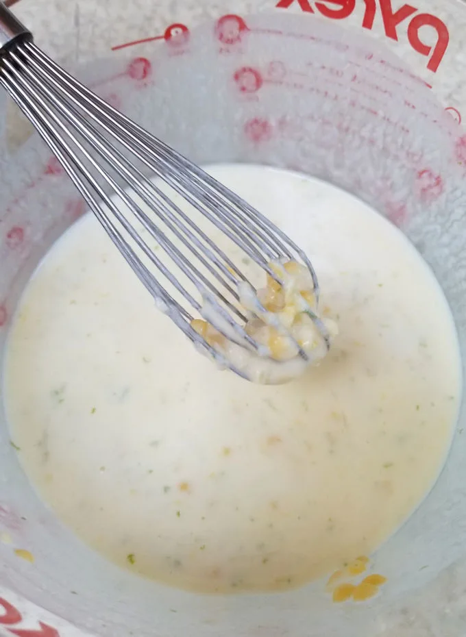 whisking corn kernels into buttermilk