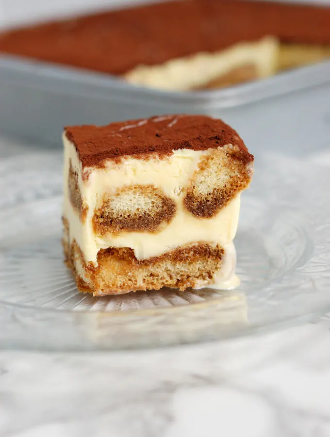 a slice of frozen tiramisu ice cream cake on a glass plate