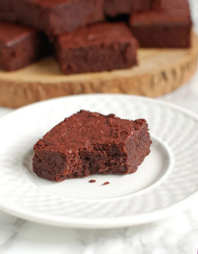 a beet brownie on a plate with a bite taken