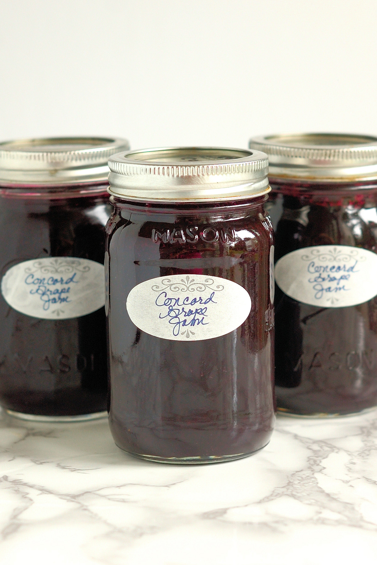 three jars of homemade concord grape jam