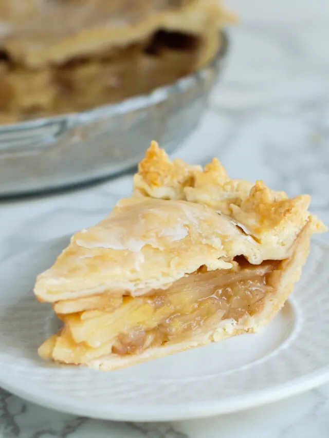a slice of apple pie on a white plate.