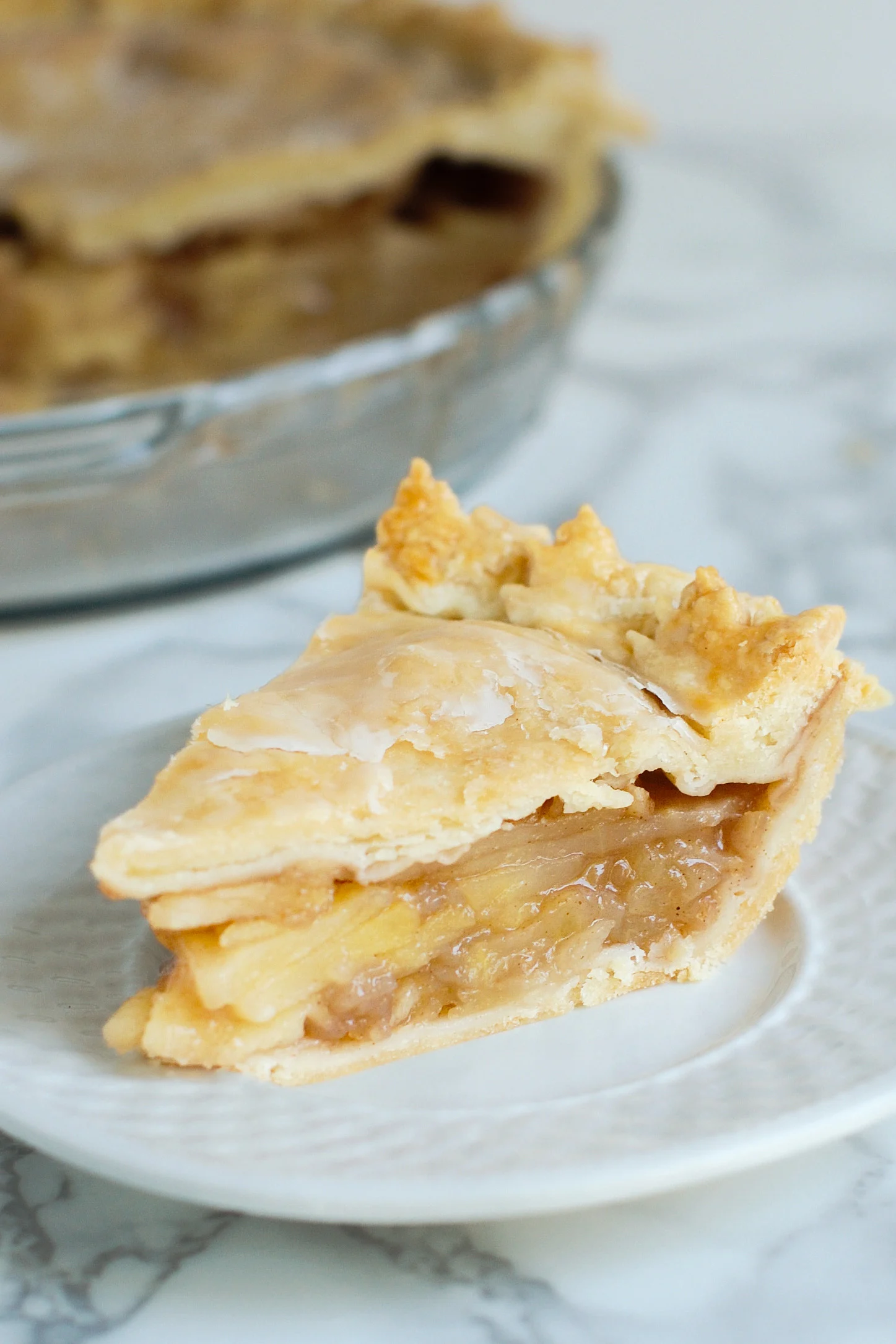 a slice of apple pie on a white plate.