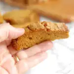 a hand holding a slice of Honey Pumpkin Bread