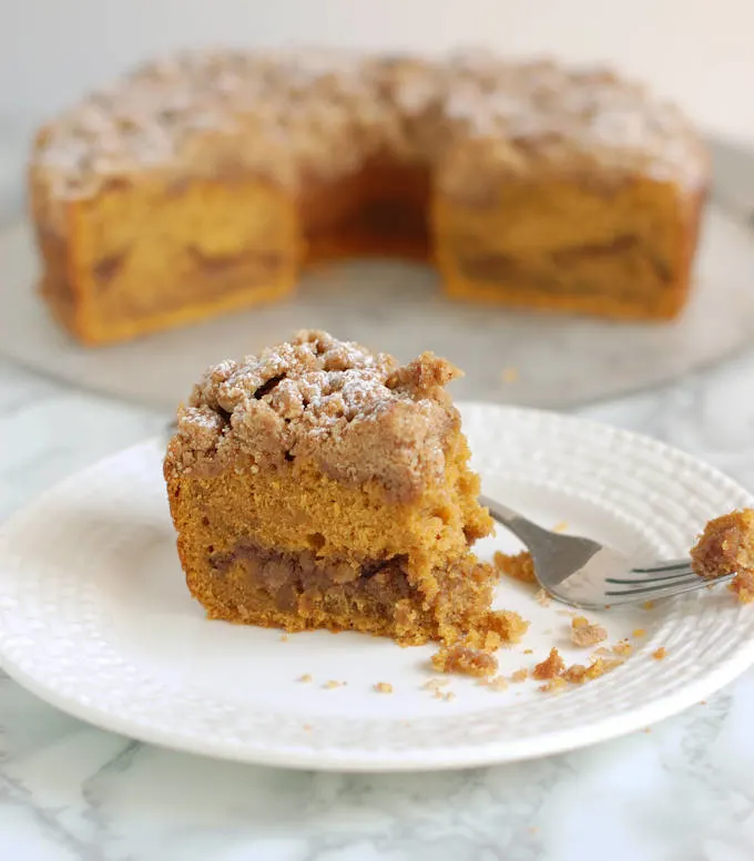 a partially eaten slice of pumpkin coffee cake on a plate 