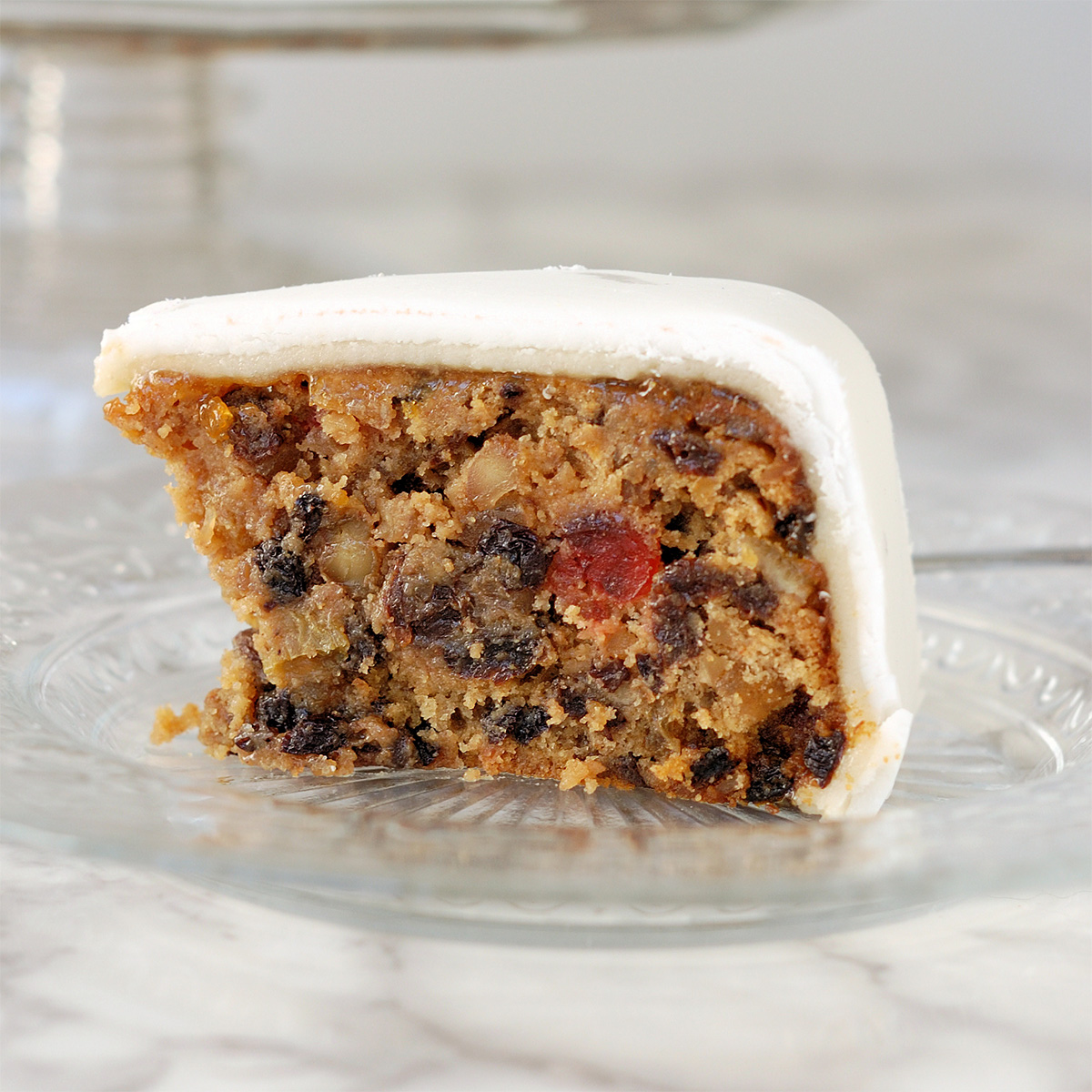 a slice of fruitcake on a glass plate.