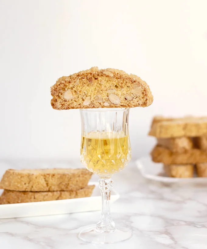 A Biscotti cookie on a glass of dessert wine