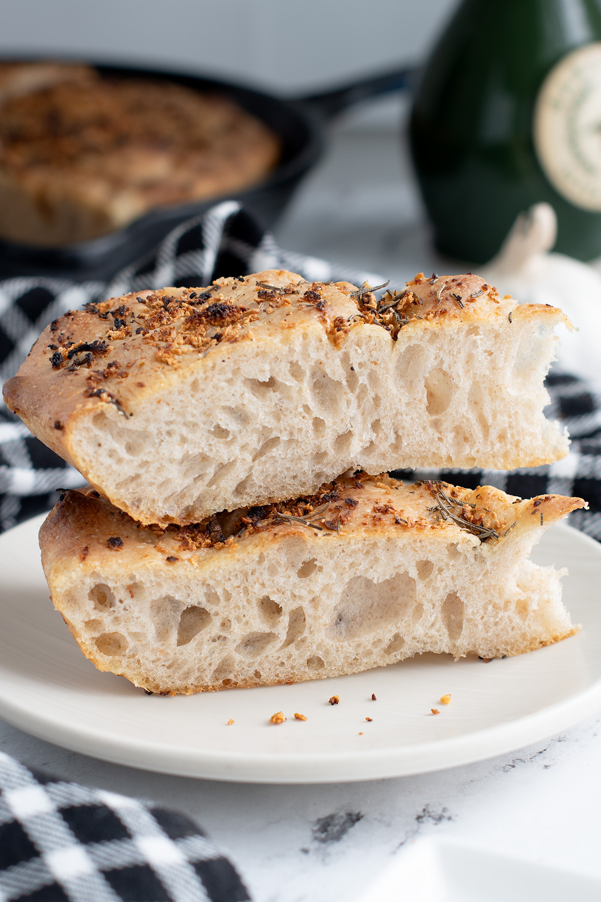 two slices of sourdough focaccia on a white plate.