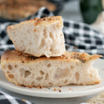 pieces of sourdough focaccia bread on a white plate.