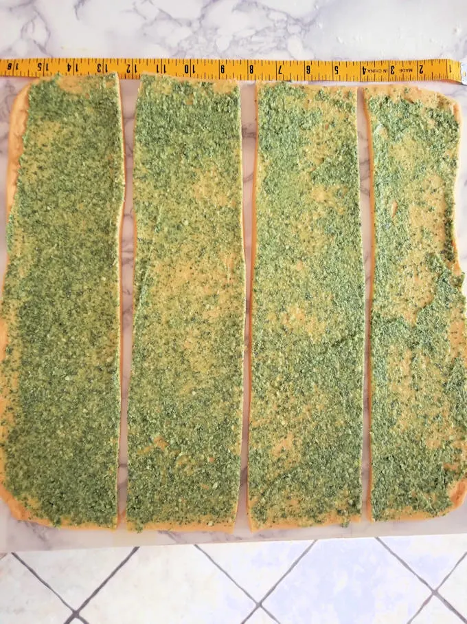 strips of pumpkin dough covered with sage pesto
