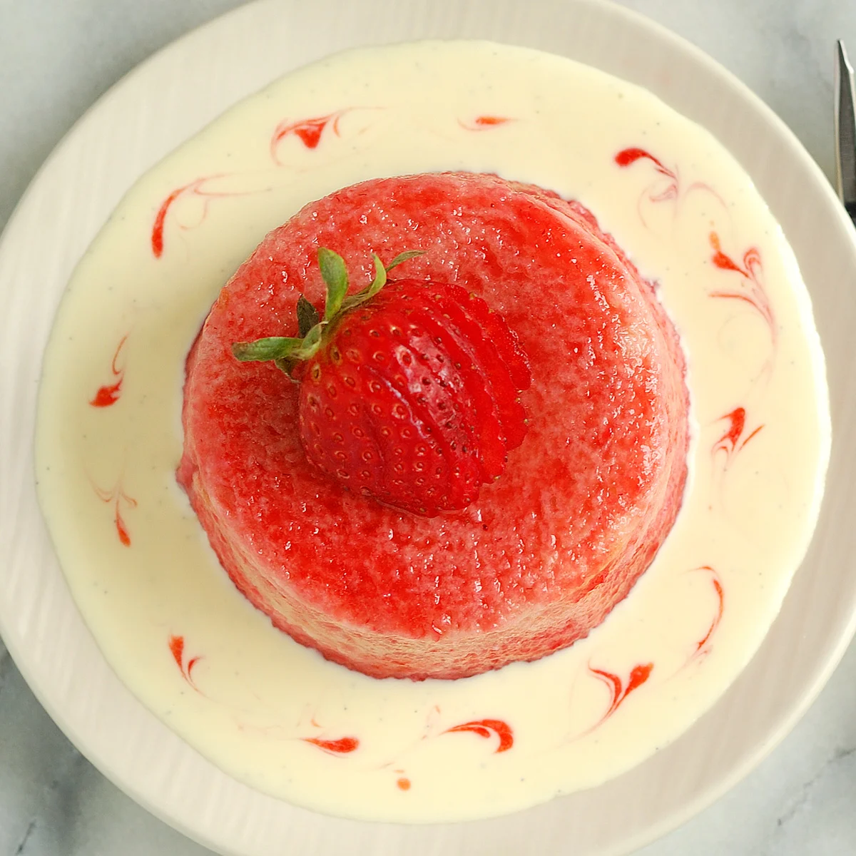 a rhubarb pudding on a plate of creme anglaise.