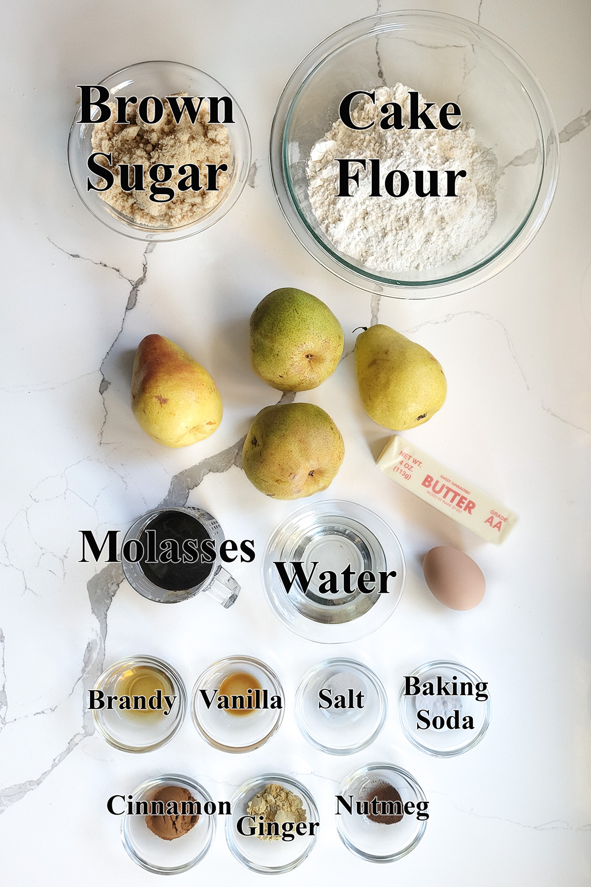 ingredients for pear gingerbread cake in glass bowls.