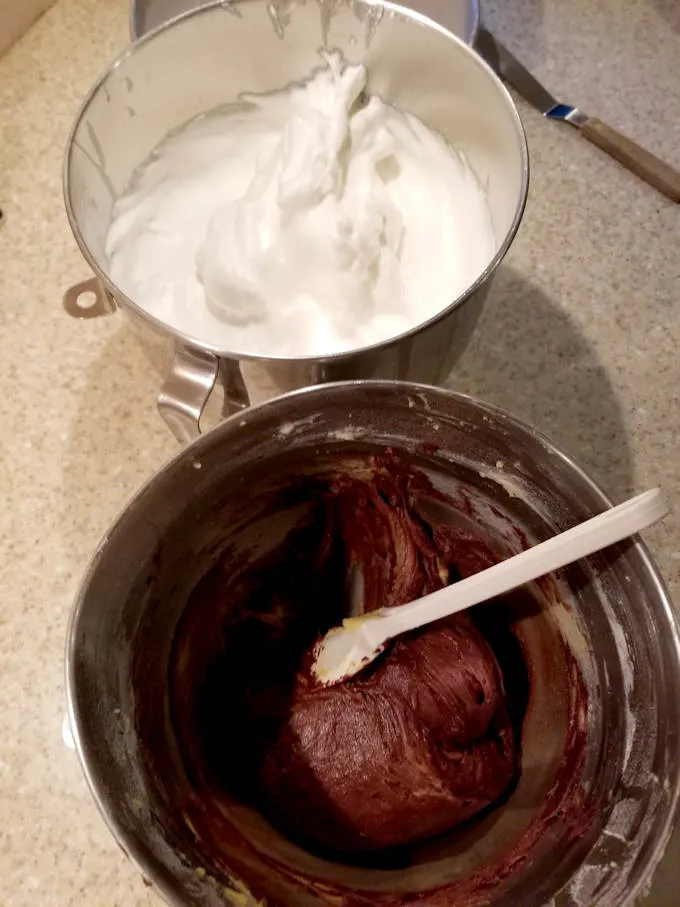 a bowl of chocolate cake batter and a bowl of whipped egg whites for making sacher torte