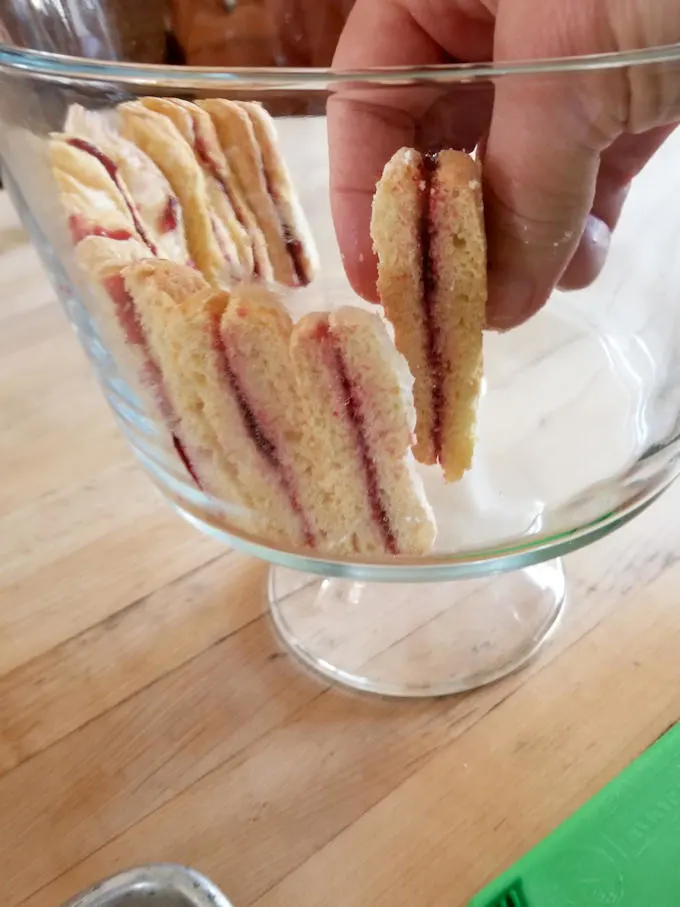 showing how to line a trifle bowl with ladyfingers
