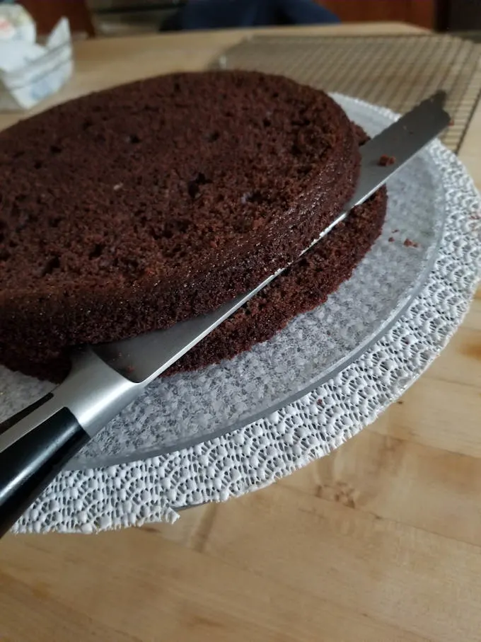 splitting a chocolate cake layer into two smaller layers.