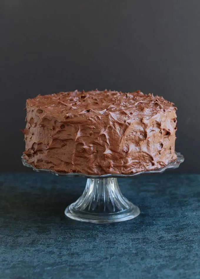 an old fashioned chocolate cake on a cake stand