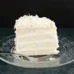 a slice of Snow White Coconut Layer Cake on a glass plate