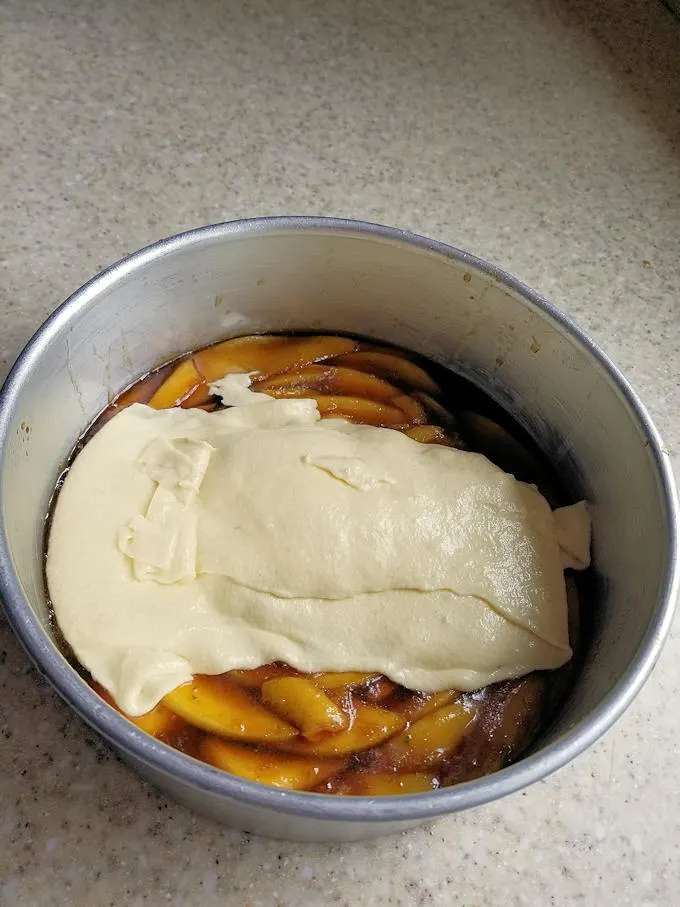 caramel, mangoes and cake batter in a pan