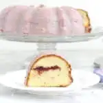 a slice of strawberry bundt cake on a white plate with cake in the background