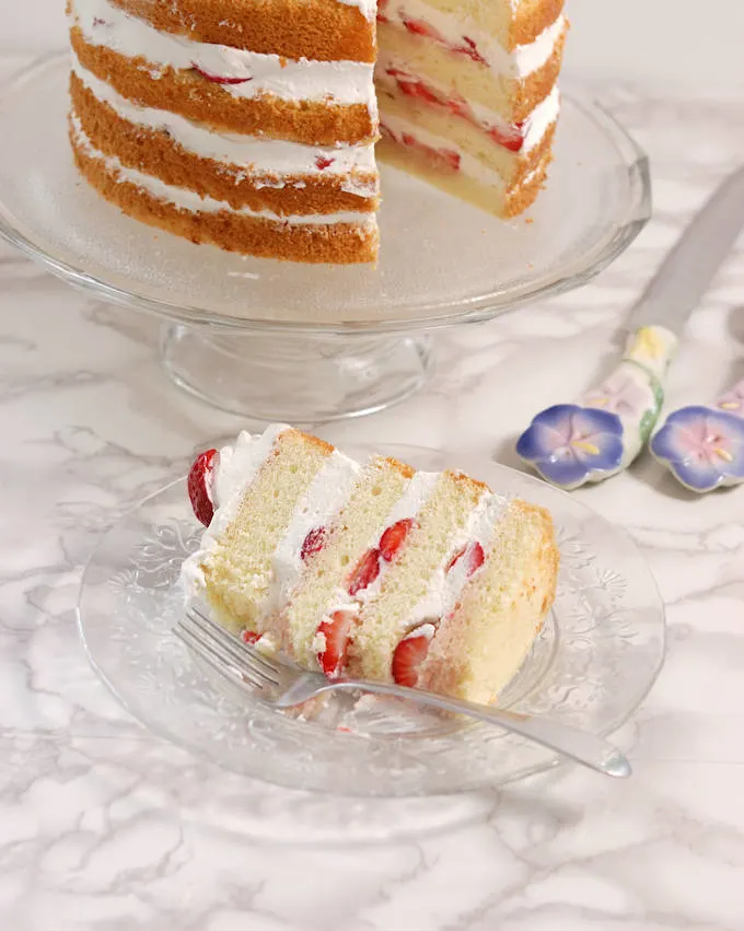 a slice of strawberry cake on a glass plate