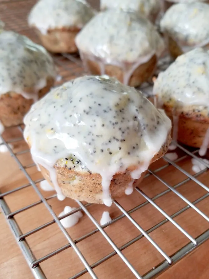 glazed lemon poppy seed muffins on a rack