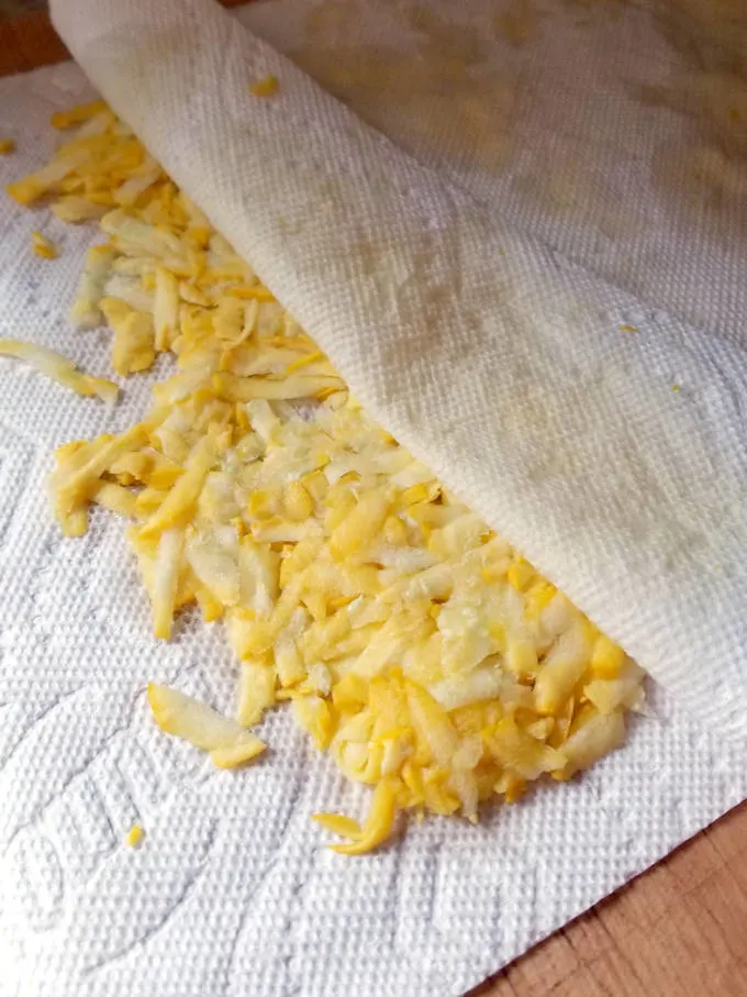 shredded yellow squash in a paper towl
