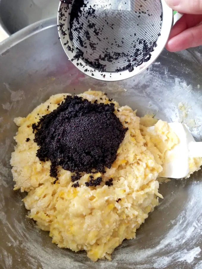 adding poppy seeds to muffin batter.