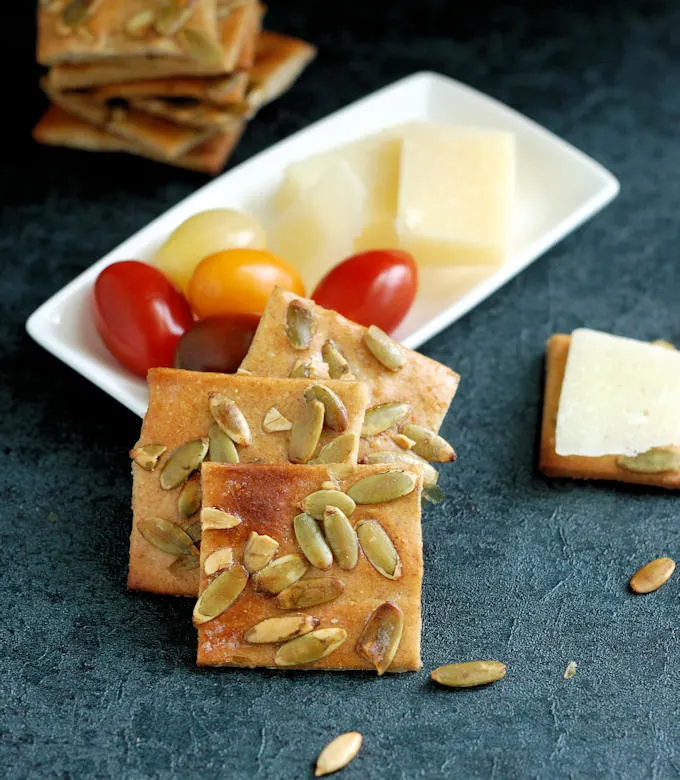 pumpkin seed crackers served with cheese and tomatoes